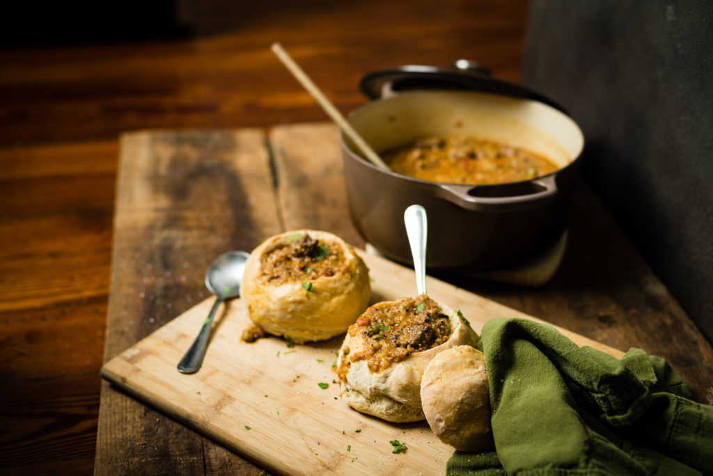 Beef Bulgur Stew in bread bowls with dutch oven behind | RealLifeWithDad.com