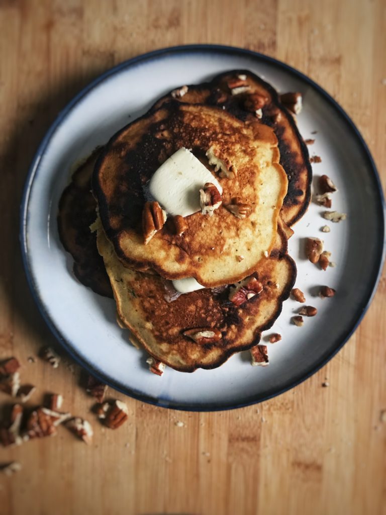 banana nut pancakes with butter, nuts and syrup on top | reallifewithdad.com