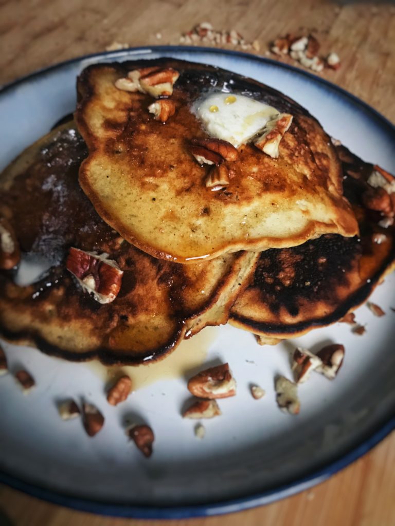 banana nut pancakes with butter, nuts and syrup on top | reallifewithdad.com