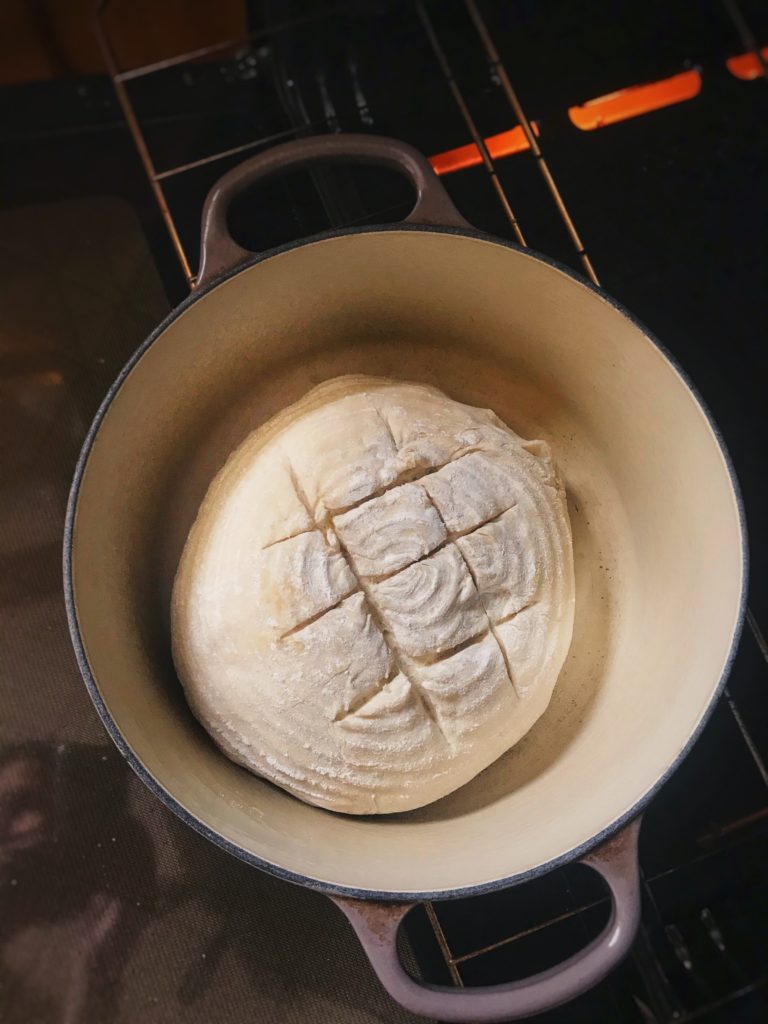 sliding the bread into the oven.