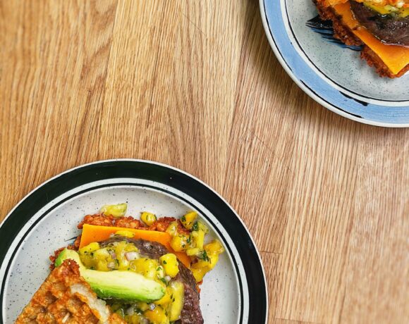 Two loaded burgers with mango salsa on a tater tot bun