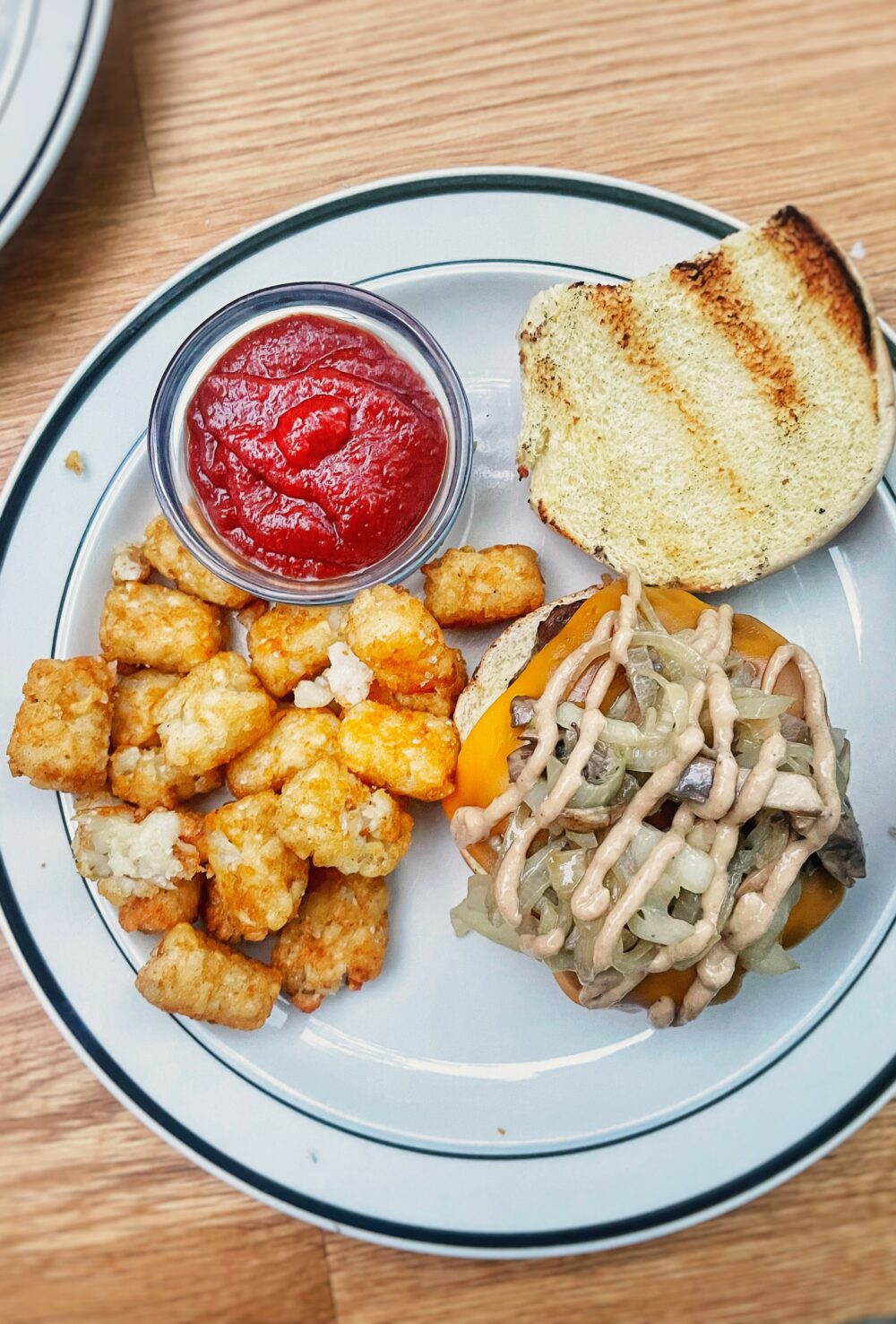 whiskey mushroom burger with tater tots on a plate